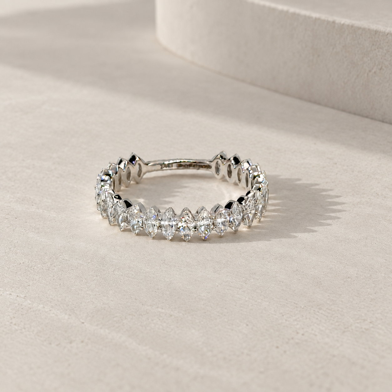 marquise diamond half eternity band in 14K white gold, set with lab-grown diamonds, photographed on a light grey-beige background with natural shadows.